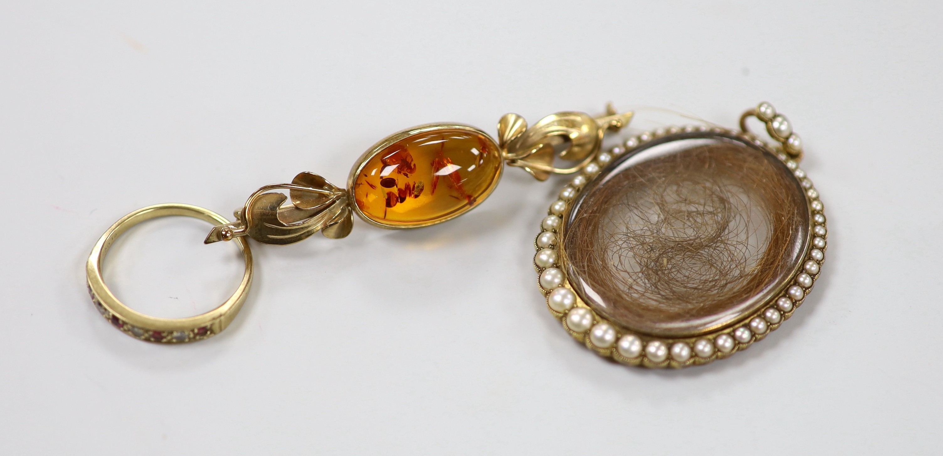 A 19th century yellow metal and split pearl mounted glazed mourning locket pendant containing a lock of hair, overall 48mm, a modern 9ct gold and gem set half hoop ring and a 9ct gold and amber set brooch.